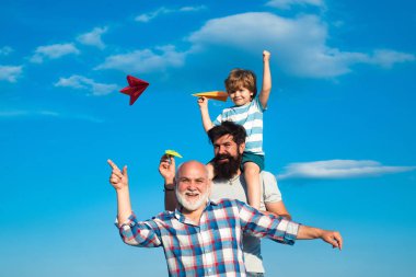 Erkekler nesil: Büyükbaba baba ve torunu kamera bakarak ve gülümsüyor sarılmak vardır. Baba ve oğul açık zevk. Aile halkı.