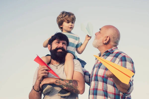 Glücklicher Vatertag. Junge mit Vater und Großvater genießen zusammen im Park vor blauem Himmel Hintergrund. Generationen Männer. Familienurlaub und Zweisamkeit. Familienmenschen. — Stockfoto