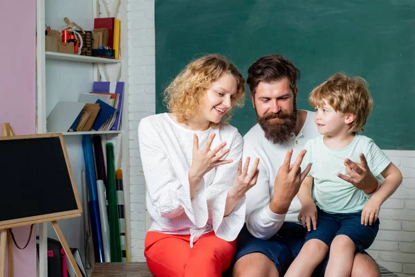 Eltern, die stolz auf den Fortschritt ihres Sohnes sind. Unterstützung der Schüler in der Schule. Zählen an den Fingern. Schulkonzept. Unterrichtsbeginn. Schüler lernen Buchstaben und Zahlen - mathematisches Konzept. — Stockfoto