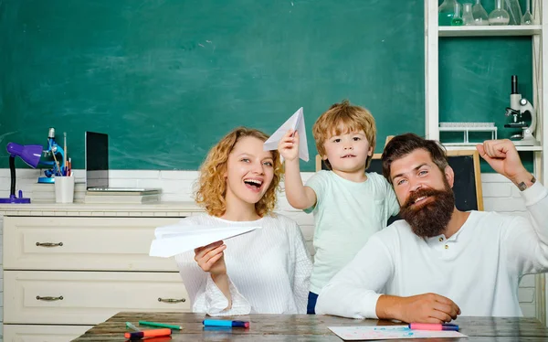 Direitos educativos da família e lei de privacidade. Exemplos de parcerias entre escolas familiares. Miúdos da escola. Aluno com avião de papel brincando com os pais . — Fotografia de Stock