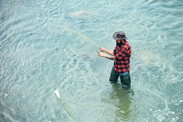 Ein Fischer mit Angelrute auf dem Fluss. Angler. Unterschied zwischen Fliegenfischen und regulärem Fischen. — Stockfoto