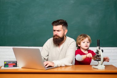 Chalkboard kopyası alanı. Babası okulda oğlunu dersine öğretiyor. Boşluk Kopyala. Öğretmen Genç çocuğa ders vermeye yardım ediyor. Adam çocuk öğretir. Öğretmen ve çocuk.