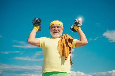 Yetmişli yıllarda kıdemli adam eğitim ve kaldırma tartmak. Yaşlı yaşlı emekli için sağlık kulübü veya rehabilitasyon merkezi. Spor merkezinde dambıl kaldırma kıdemli spor adam.