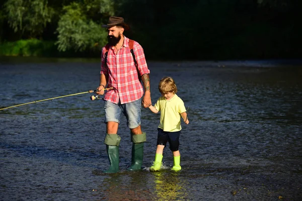 Счастливый отец и сын вместе рыбачат в летний день под красивым небом на реке. Отец и сын рыбалки и отдыха, наслаждаясь хобби . — стоковое фото