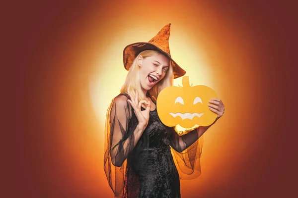 Femme de beauté posant avec citrouille et chapeau d'Halloween. Portrait en gros plan de la magnifique enchanteresse blonde de la fée, couvrant ses yeux avec la casquette, la figure chaude, le corps. Lanterne Jack tête de citrouille . — Photo