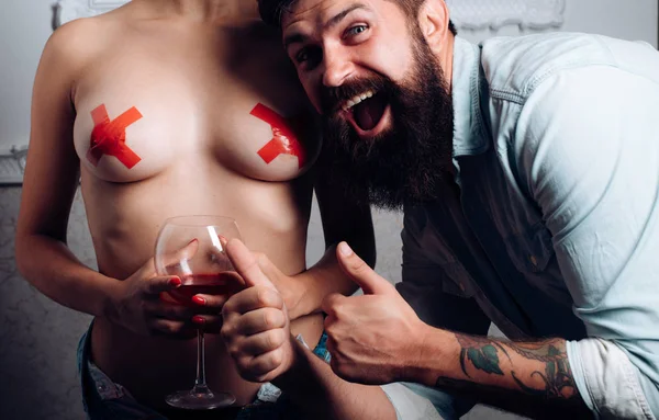 男人享受前戏与性感的女士。快乐的胡子男子竖起大拇指。裸露的女性乳房隐藏与红色胶带绳。审查。女人喝酒喝酒。恋爱中的情侣 — 图库照片