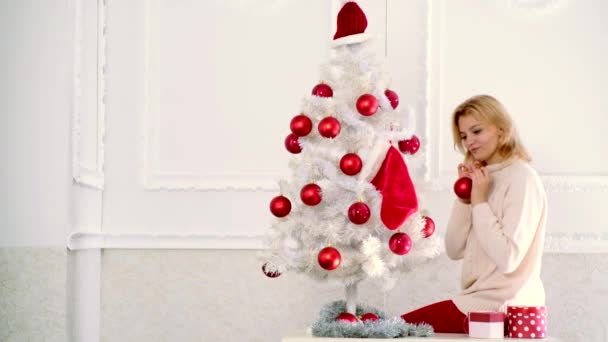 Καλά Χριστούγεννα και ευτυχισμένο το νέο έτος. Κορίτσι παρασημοφορημένο χριστουγεννιάτικο δέντρο, φορώντας χριστουγεννιάτικο φόρεμα. Αισθησιακό κορίτσι για τα Χριστούγεννα. — Αρχείο Βίντεο