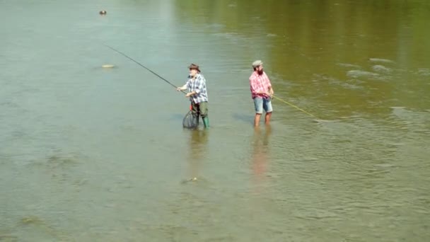 父と息子が居る茶色のマスの魚父と息子は一緒にくつろいでいる。世代の男性。男釣り夏の日中は川で釣りをする男性。父と息子の釣り. — ストック動画