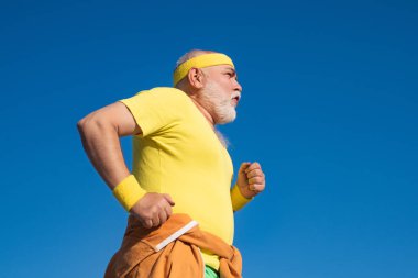 En iyi kardiyo egzersiz. Yolda koşan yaşlı ve genç sporcular. Sağlıklı yaşlı spor adamıportresi. Yaz ve hareketli tatiller.