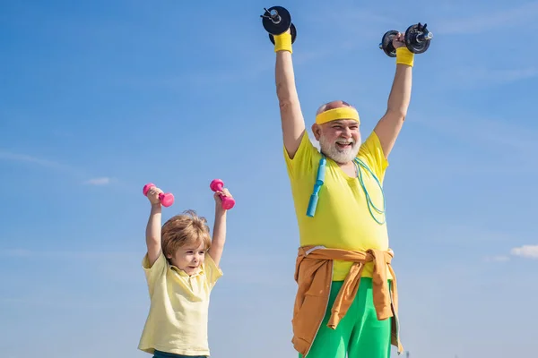 Fare sport è gratuito. Adoro lo sport. Sport per bambini piccoli. Nonno sportivo e bambino sano con esercizio manubri. Formazione padre e figlio insieme . — Foto Stock