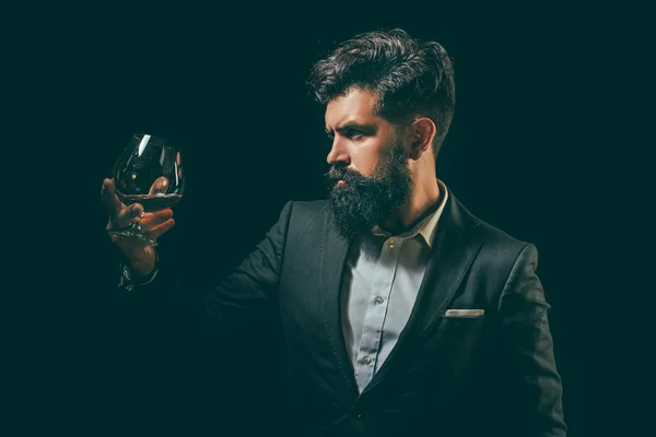 Man met baard houdt glas brandewijn. Degustatie en proeverij. Nippen van whiskey. — Stockfoto