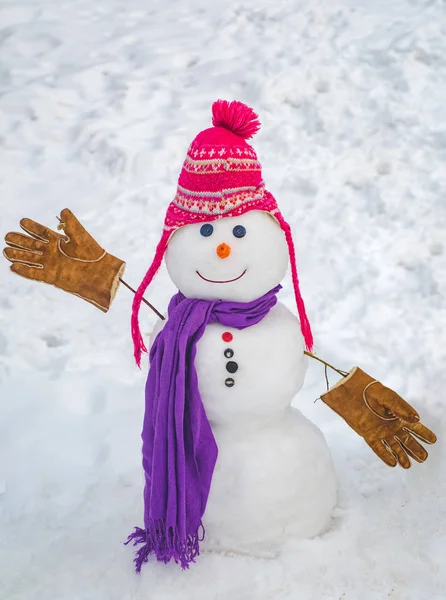 Merry Christmas and Happy new year. Snowmen. Happy smiling snow man on sunny winter day. Snow man in winter hat. Cute snowman in hat and scarf on snowy field.