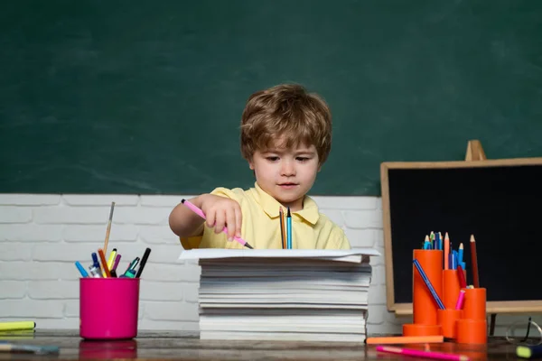 学校に戻れかわいい小さな就学前の子供の男の子は、教室で勉強します。教育と読書の概念。教師の日. — ストック写真