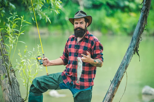 Άνθρωπος ψάρεμα και χαλάρωση απολαμβάνοντας το χόμπι. Οι άντρες ψαρεύουν στο ποτάμι κατά τη θερινή ημέρα. Ψάρεμα με μύγα. — Φωτογραφία Αρχείου