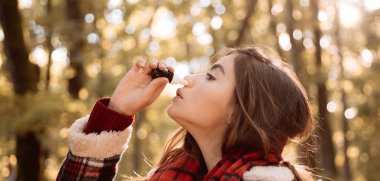 Kadın sonbahar parkında soğuk algınlığı için bir çare yapar. Mendili olan genç bir kadın. Hasta insanların burnu akmış. Burnu ve ateşi olan hasta bir kız. Alerji mevsimi. Soğuk algınlığı mevsimi burun akıntısı.