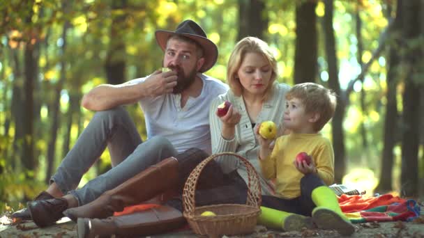 가을 배경에 자연과 건강한 가족. 가족 부모와 사람들의 개념 - 가을 공원에서 행복한 어머니 아버지와 어린 소년. 행복한 가을 가족입니다. 노란 자연 속에서 함께 하는 가족. — 비디오