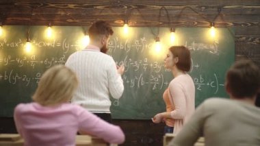 Sınıf Arkadaşı Eğit arkadaş bilgisi ders kavramı. Öğretmen ve öğrenci. Okula geri dön. Öğrenme kavramı. Sınıfta öğretmen. Kız öğrenci, yakın tahtadaki matematik dersinde öğretmenle iletişim kuruyor.