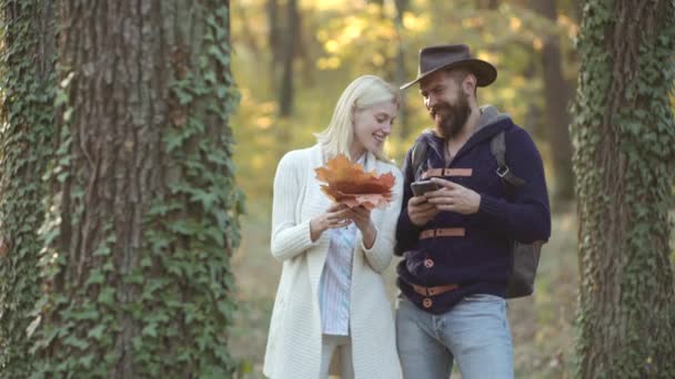 Mode höst modeller poserar i parken. Mode höst porträtt kvinna och man med gula lönn löv på natur bakgrund. Romantisk och kärlek. — Stockvideo