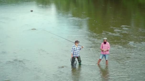 Vader en zoon ishing. Vliegvisser met behulp van vlieg hengel in de prachtige rivier. Familie en generatie-zomer vakantie en People concept. Man vissen en ontspannen terwijl u geniet van hobby. — Stockvideo