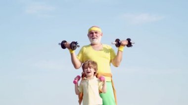 Büyükbaba ve çocuk halter kaldırıyor. Sağlıklı yaşam ve spor konsepti. Dedesi dambıl ile egzersiz çocuk yardım.