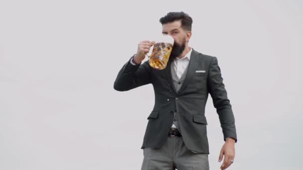 Divertente hipster barbuto ubriaco tiene birra artigianale. Uomo elegante ed elegante in classico indossare tenendo il vetro con la birra in mano . — Video Stock