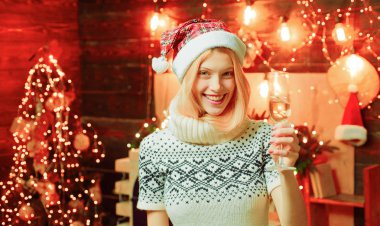 Elinde şampanya olan bir Noel odasında çekici bir kadın. Sarışın kız. Şerefe.
