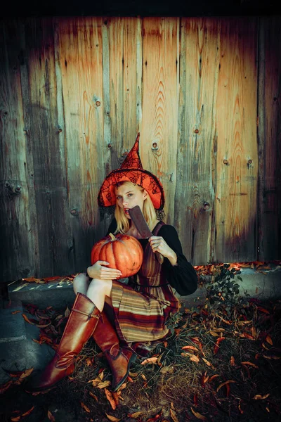 Diseño de mujer de Halloween. Bruja en el sombrero de Halloween posando al aire libre. Una jovencita guapa disfrazada de bruja. Decoración de Halloween. Imagen tonificada. Copiar espacio . —  Fotos de Stock