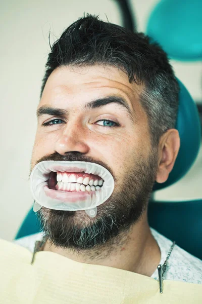 Homme mignon souriant regardant caméra. Portrait d'un homme joyeux avec des dents blanches comme neige. Homme âgé ayant un traitement dentaire au cabinet des dentistes. Professionnalisme service médecine santé concept . — Photo