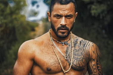 Dövmeli, vahşi, yakışıklı bir adam. Erkekler sıradan dövmeler yaptırır. Dışarıdaki yakışıklı erkek modelin vahşi portresi. Çıplak gövdeli kaslı, seksi bir erkek.