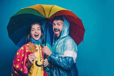 İnsanlar yağmurda. Sonbahar havası ve hava sıcak ve güneşli ve yağmur yağabilir. Yağmur ve şemsiye Kasım konsepti. Sonbaharda mutlu bir aile.