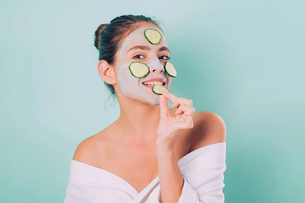 Beleza natural. Menina arrepiante fazendo máscara facial de barro com pepino. Saúde da pele. Mulher adorável menina muito sorridente com máscara de barro. Limpeza e cuidados para a pele jovem. Abordagem adequada para limpar a pele — Fotografia de Stock