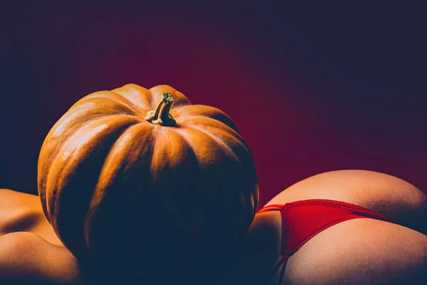 Halloween vrouw ontwerp. Viert Halloween. Pompoen op vrouw met sexy kont en terug. Kopieer ruimte. Verkoop op lingerie. Sensuele kont met hallowen pompoen. — Stockfoto