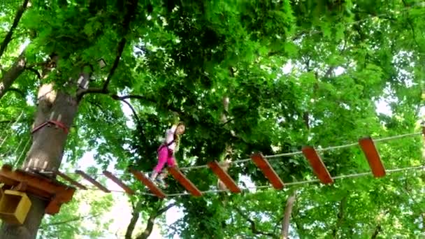 Kind. Eco Resort activiteiten. Actieve kinderen. Kinderen plezier. Helm-veiligheidsuitrusting voor klein meisje spelen. Gelukkig klein meisje klimmen een boom. Adventure Climbing High Wire Park. Peuter leeftijd. — Stockvideo