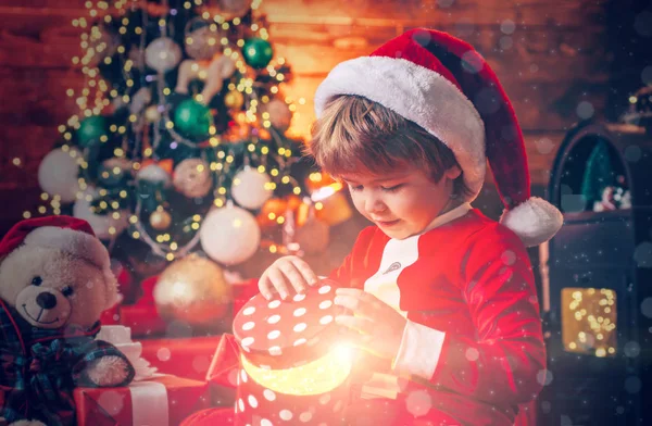 Papai Noel menino comemorar o Natal em casa. Bebê adorável desfrutar de Natal. Férias em família. Menino bonito criança alegre humor jogar perto da árvore de Natal. Feliz e brilhante Natal — Fotografia de Stock