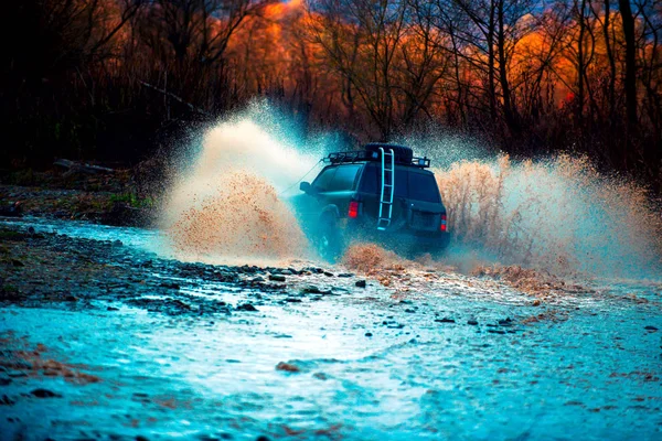 Offroading. A car during a tough off-road competition diving in a muddy pool. Extreme weekends. — Stock Photo, Image