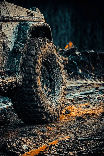 Bottom view to big offroad car wheel on country road and mountains backdrop. — Stock Photo, Image