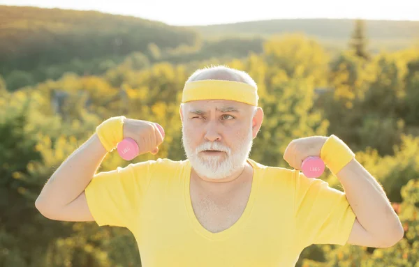 아령으로 운동하는 할아버지. 노인을위한 스포츠. 공원에서 노인 은 무게와 함께 운동. — 스톡 사진