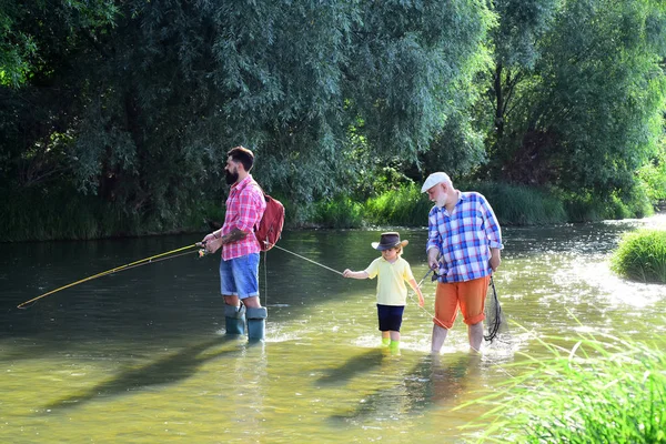 Tre generazioni di età: nonno, padre e giovane figlio adolescente. Vecchi e giovani. Papà e figlio pesca al lago . — Foto Stock