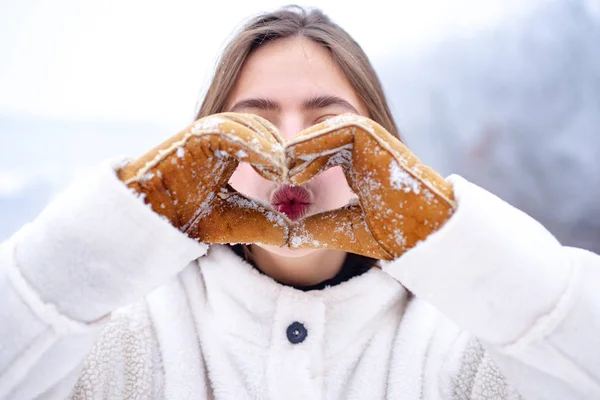 Lip care in winter. Healthy lips of a beautiful woman. Moisturizing. Woman hands in winter gloves Heart symbol shaped Lifestyle and Feelings concept. Lip balm moisturizing balsam. — Stock Photo, Image