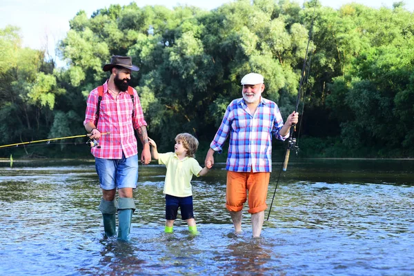 Ritratto di figlio, padre e nonno felice - tre generazioni di uomini che pescano sul fiume. Buon pescatore con canna da pesca . — Foto Stock