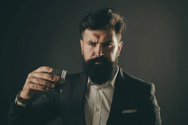 Stylish rich man holding a glass of old whisky. Stylish elegant bearded man Bartender holds whiskey glass. — Stock Photo, Image