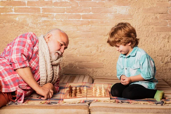 Loisirs d'échecs - grand-père avec petit-fils sur un jeu d'échecs . — Photo
