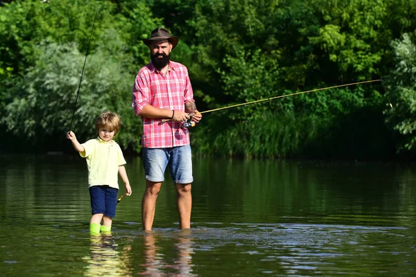 Pesca. Pescatori padre e figlio pesca in un fiume con una canna da pesca. La pesca è diventata un'attività ricreativa popolare . — Foto Stock