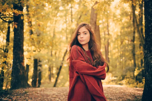 Mulher de moda bonita no outono vestido vermelho com folhas caindo sobre o fundo da natureza. Outono ao ar livre retrato de bela menina feliz andando no parque ou floresta em cachecol de malha quente — Fotografia de Stock