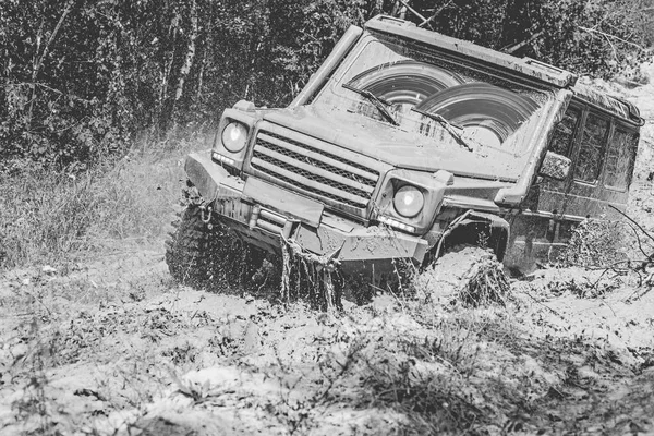 Conceito de viagem com carro 4x4. Veículo off-road vai para a montanha. Veículo offroad saindo de um perigo de buraco de lama. Foto em preto e branco . — Fotografia de Stock