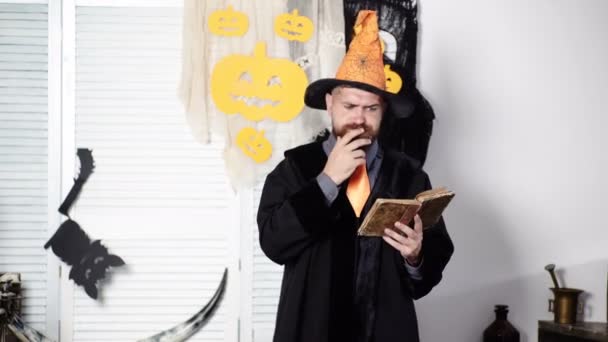 Magi, spell, bok av magi. Skäggiga trollkarl läser gamla bok om magi. Halloween-guiden. Bearded man i Halloween kostym. Bearded man läsa magi bok. Tankeväckande man läsa bok. Bus eller godis. — Stockvideo