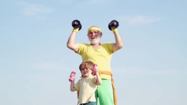 Aktif aile spor ve zindelik keyfini çıkarın. Komik yaşlı yaşlı adam ve dambıllı çocuk. Büyükbaba ve Çocuk sabah egzersizyapmak.
