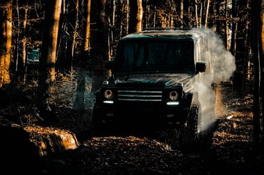 Tekerlekleri hareket ettirebilen lastikler ve kumdaki toz içinde giden off-road. Jeep açık maceralar. Off-road araç dağ yolunda gidiyor. 4x4 seyahat trekking. Ralli yarışı.