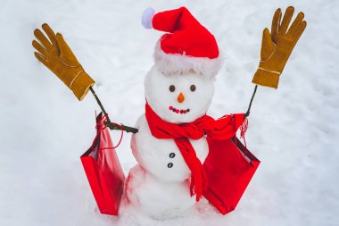 Satılık kardan adam. Kutlama Sanat Kutlama Kartı. Kar tarlasında şapkalı ve atkılı şirin bir kardan adam ve sürpriz bir Noel hediyesi. Mutlu Noeller ve fotokopi alanı olan mutlu yıllar..