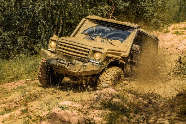 Geländewagen geht auf den Berg. Reifen in Vorbereitung auf das Rennen. Schlamm und Wasser plätschern im Gelände. Safari-Geländewagen. Jeep krachte in Pfütze und sammelte Dreck auf. — Stockfoto